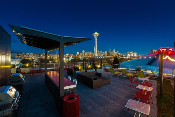 ultra-modern-outdoor-kitchen-with-black-pergola-and-green-lounge-chairs-plus-glass-rooftop-patio-in-wonderful-seattle-apartment-600x400